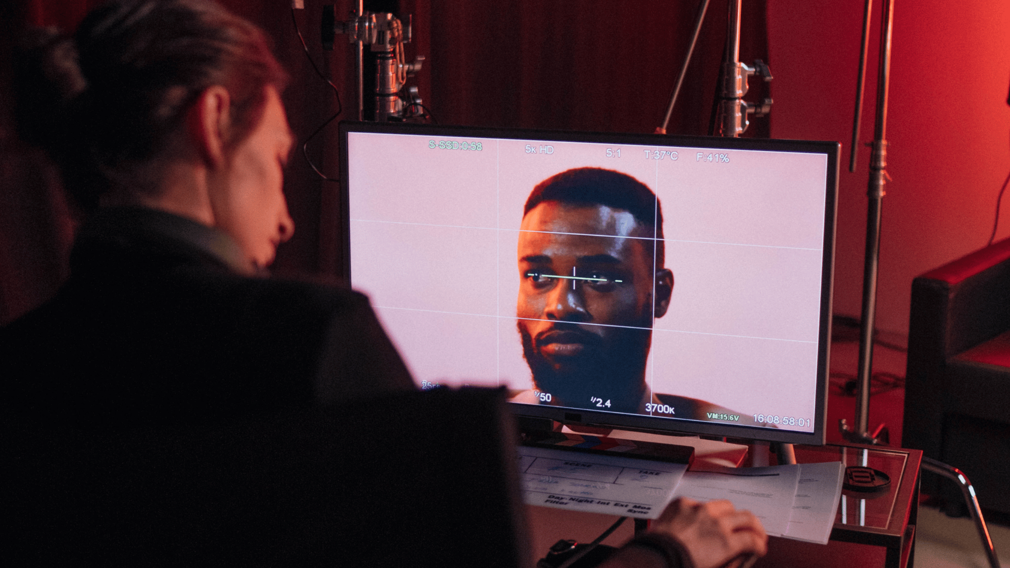 video producer sitting in front of a screen checking the composition of a video shot