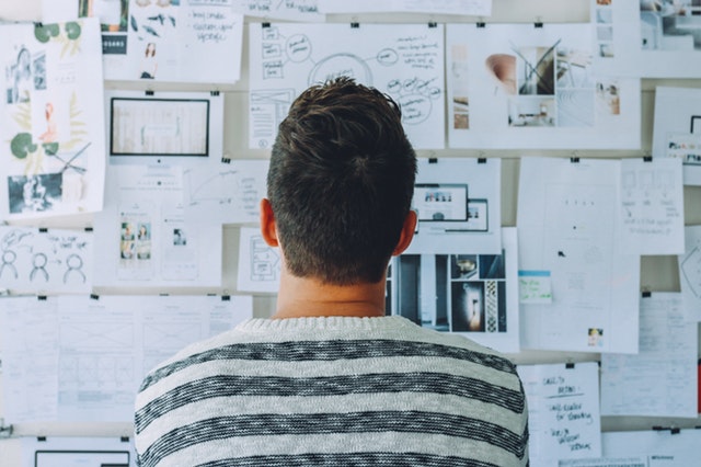A man looking at a board of notes he is using to help him find the best animated video production service