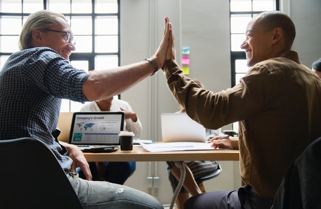 Two men high fiving because they found great explainer video companies