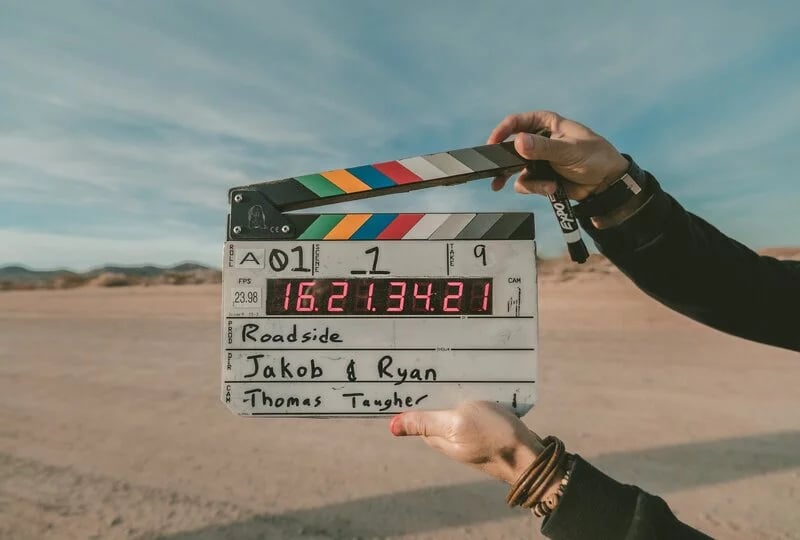 Man holding clapboard as part of the video production process