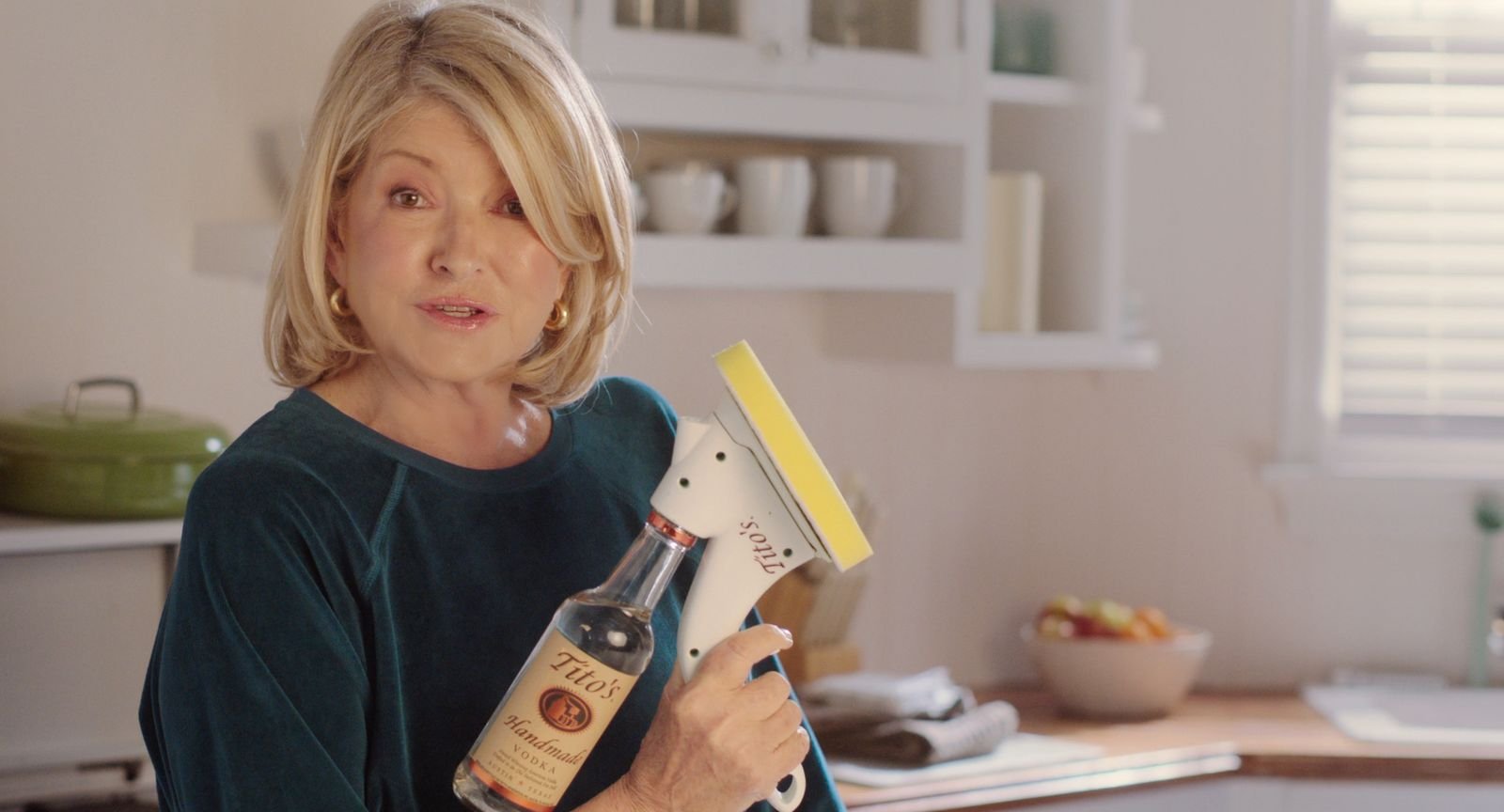Martha Stewart holds up a cleaning product filled with Tito's Vodka