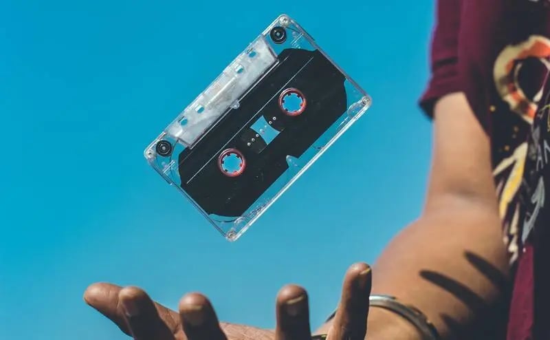 A casette tape floating with a blue sky backdrop