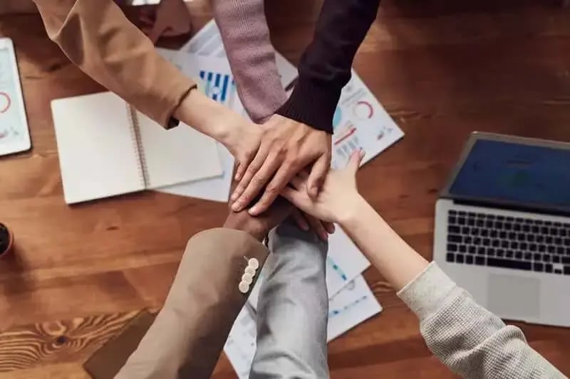 People piling hands upon one another, having decided to partner with animated video agency
