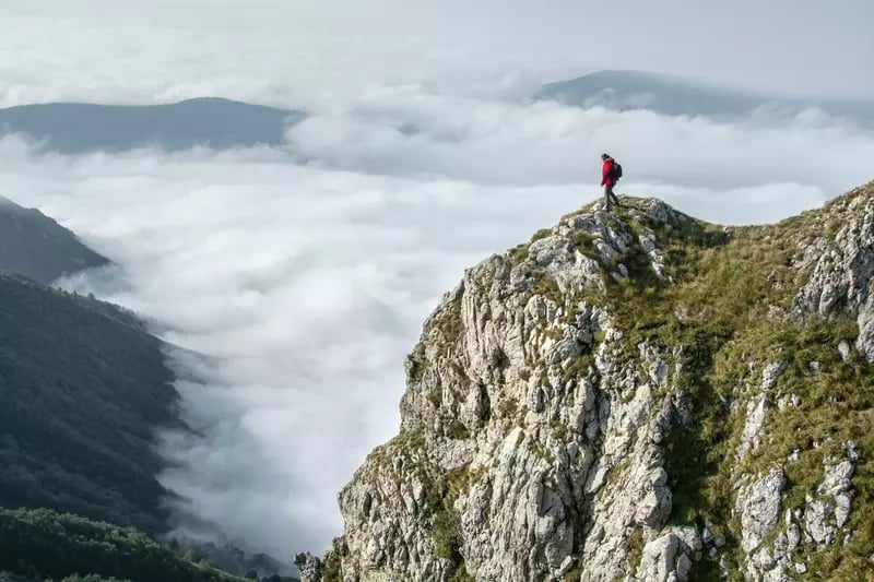 Man location scouting on top of a mountain