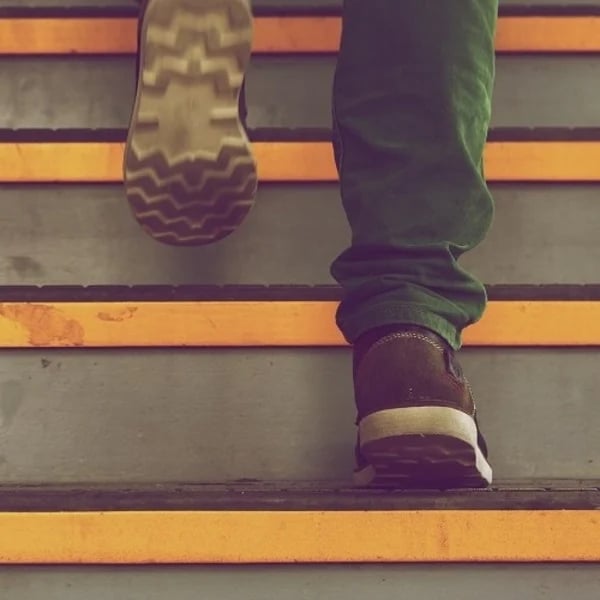 A man climbing stairs that represents video production step by step
